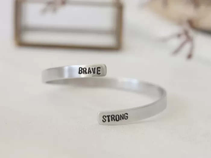 Spiralna zapestnica z napisom BRAVE STRONG